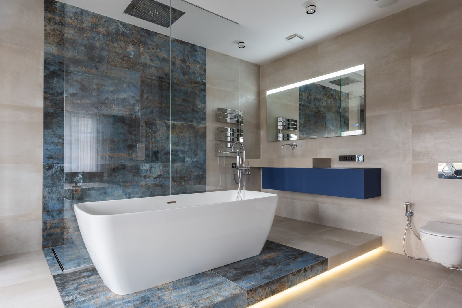 Modern bathroom with a freestanding bathtub, blue vanity and glass shower