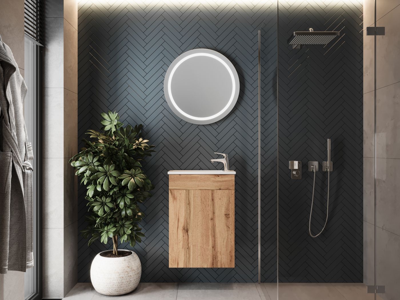 Wood bathroom vanity with a round illuminated mirror, greenery and dark herringbone wall finish
